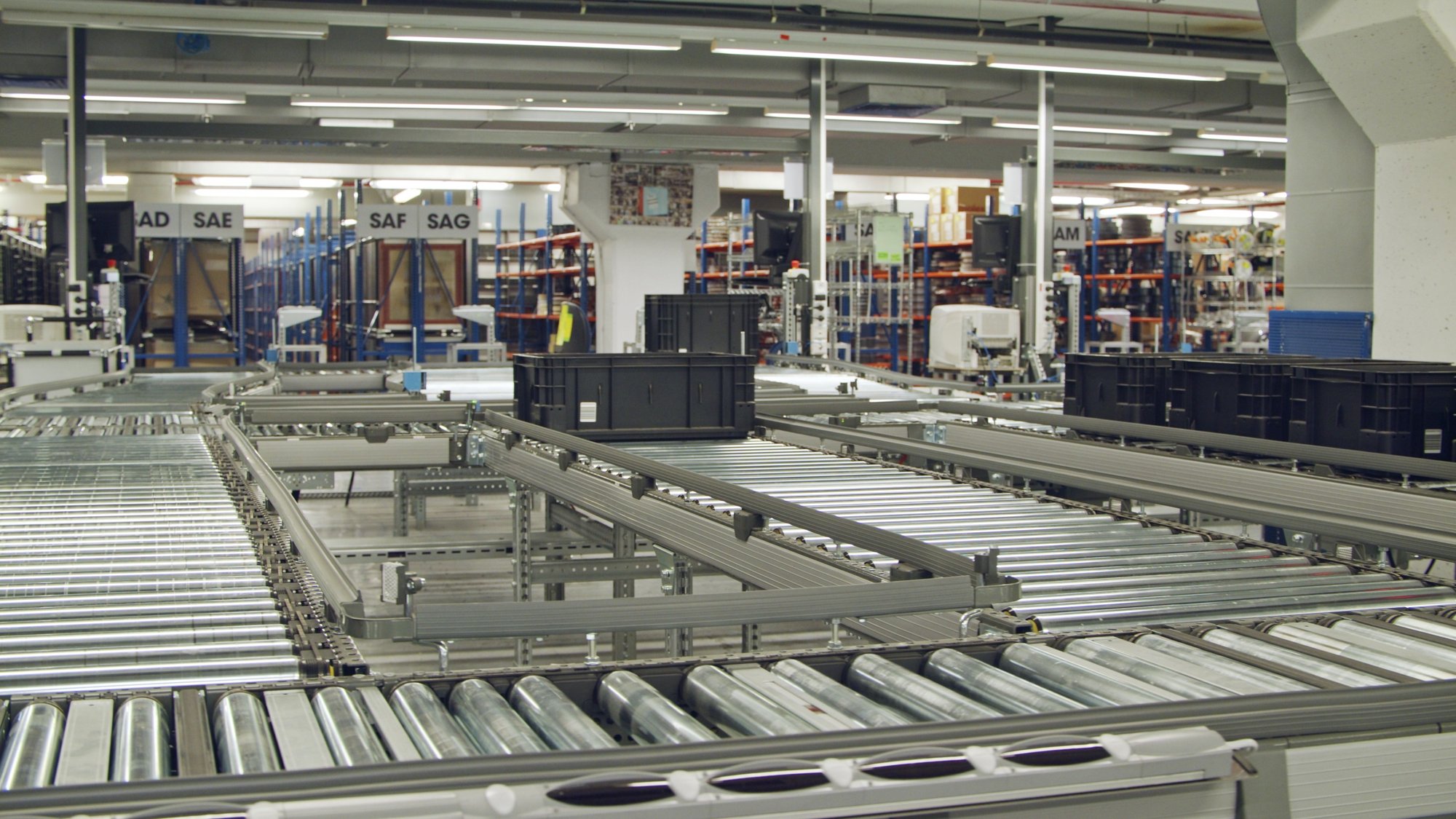 boxes-on-a-conveyor-belt-in-a-large-automated-warehouse-SBI-351574312